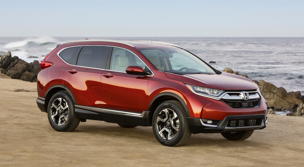 A red 2017 Honda CR-V, popular among used SUVs for sale, is parked at the ocean.