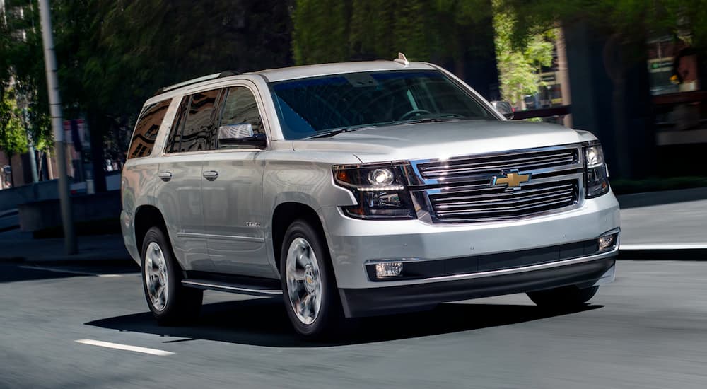 A silver 2019 Chevy Tahoe is driving on a multi-lane city road.