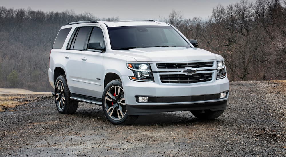 A white 2019 Chevy Tahoe is parked on a dirt road during dusk. 