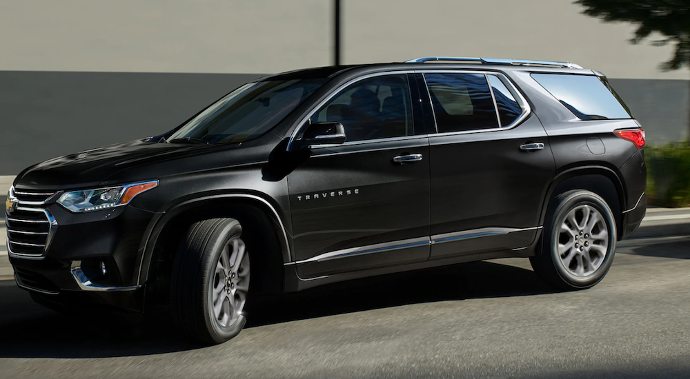 A black 2019 Chevy Traverse is backing into a parking spot.