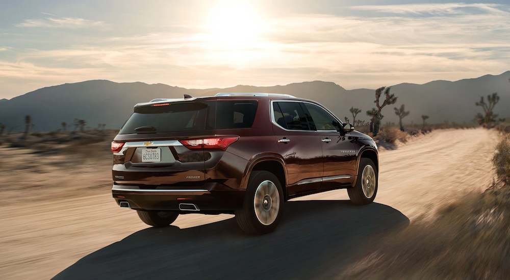 A burgundy 2019 Chevy Traverse is driving through the desert.