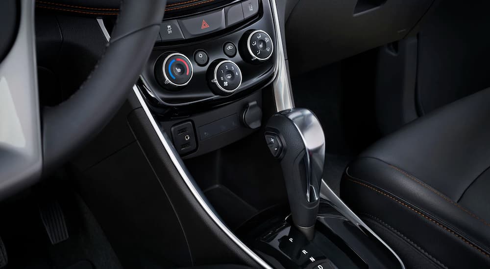 Black interior features of the 2019 Chevy Trax center console are shown.