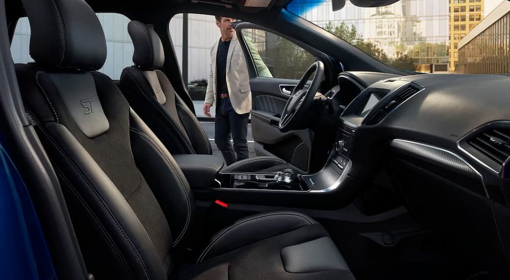 A man is getting into his 2019 Ford Edge with black interior.