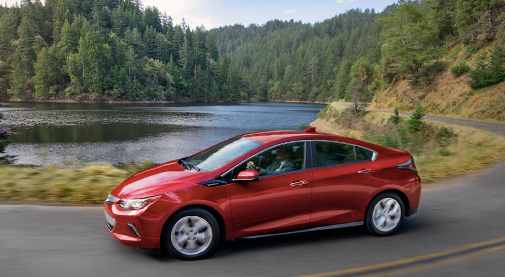 A red 2019 Chevy Volt is driving around a pond after leaving an Atlanta Chevy dealer.