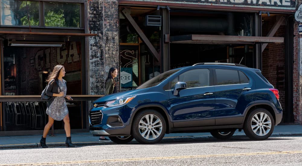 Two women are walking to their blue 2019 Chevy Trax outside a cafe.
