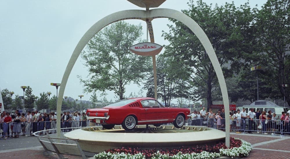 A red 1965 Ford Mustang is on display at the 1964 Worlds Fair.