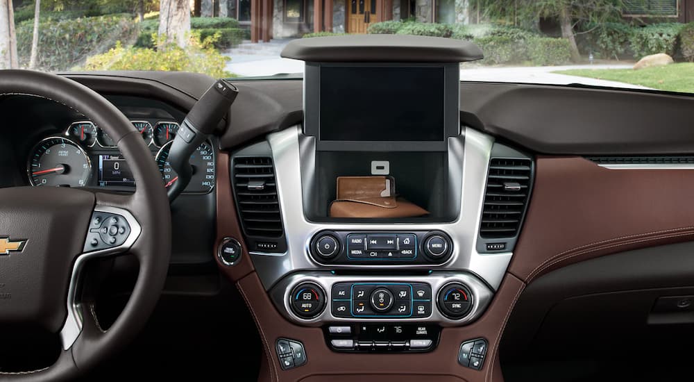 A wallet is in the compartment behind the screen in a 2020 Chevy Tahoe's interior.