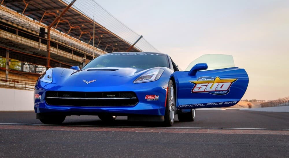 The blue 2014 Corvette Stingray Pace Car is shown on the track.