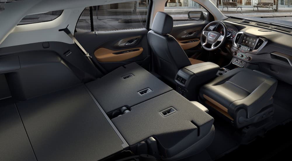 The black interior of a 2019 GMC Terrain is shown with its back seats folded down.