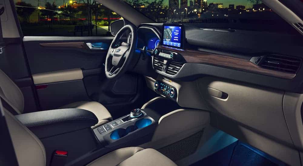 The front tan leather interior of a 2020 Ford Escape with ambient lighting is shown. 