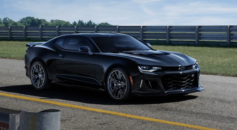 A black 2020 Chevy Camaro ZL1 is parked on a racetrack.