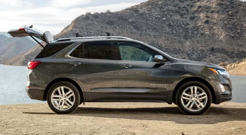 A grey 2020 Chevy Equinox is parked at a lake with the trunk open.