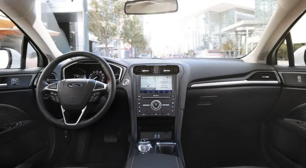 The front black leather interior of a 2020 Ford Fusion is shown. 