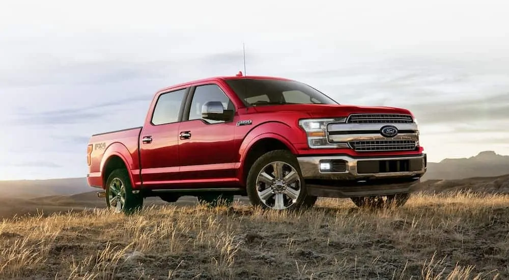 A red 2020 Ford F-150 is in a field.