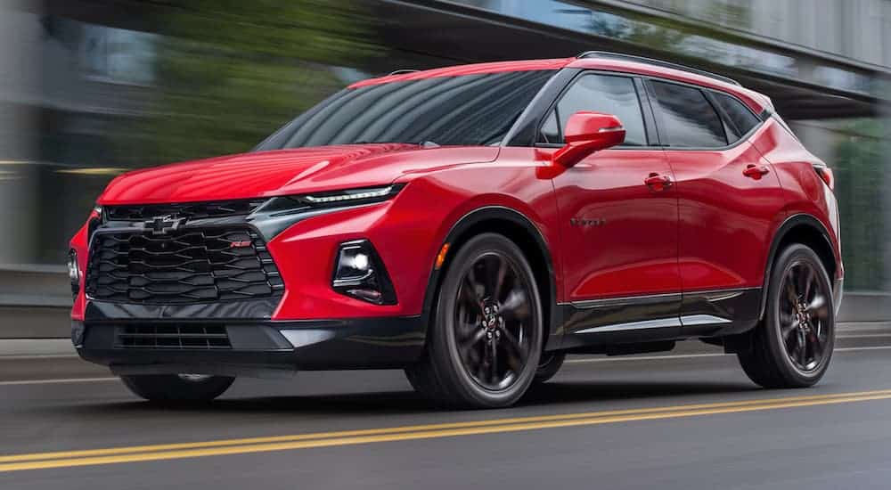 A red 2019 Chevy Blazer is driving on a city street.