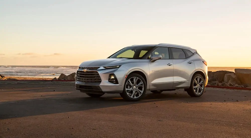 A silver 2020 Chevy Blazer Premier is parked next to a beach at sun set.