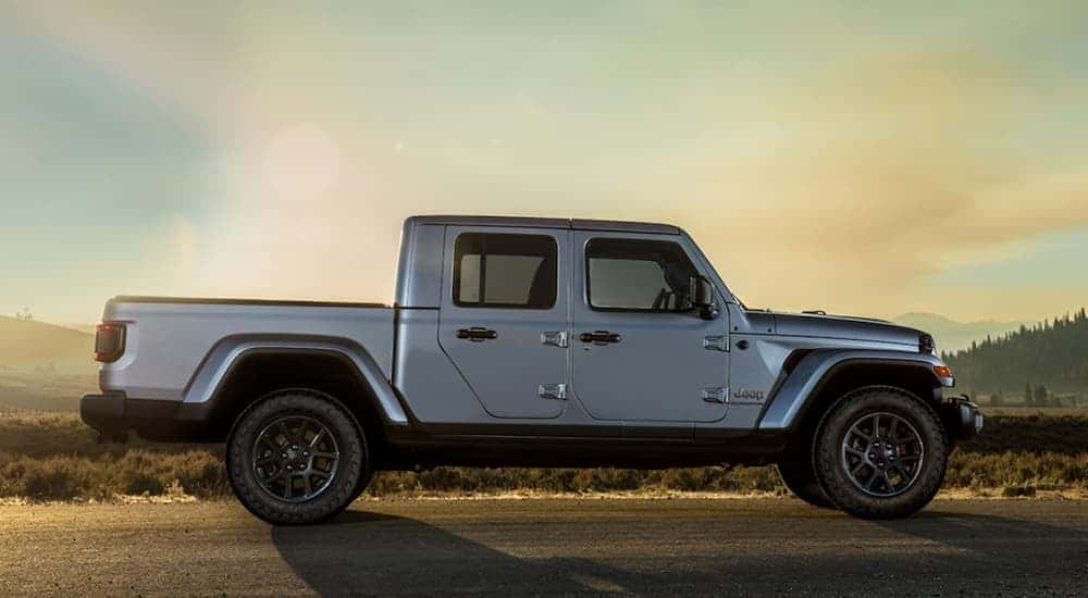 A silver 2020 Jeep Gladiator is shown from the side on a desert road.