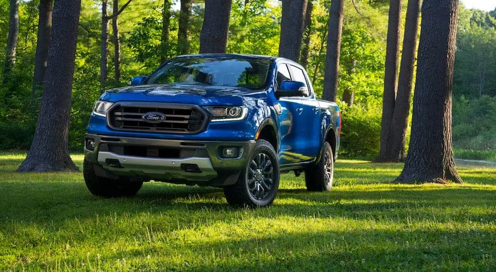 A blue 2020 Ford Ranger with the FX2 package is parked the grass in the shade. 