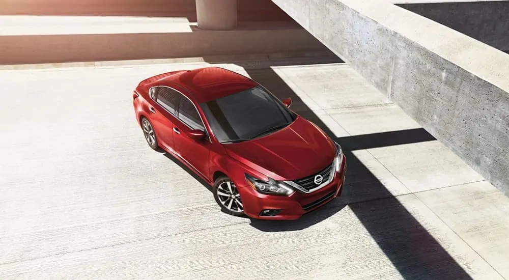 A birds eye view of a red 2018 Nissan Altima that's parked in an empty outdoor parking garage is shown.