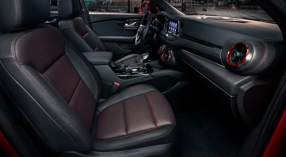 The front black red leather interior of a 2020 Chevy Blazer is shown with an infotainment system. 