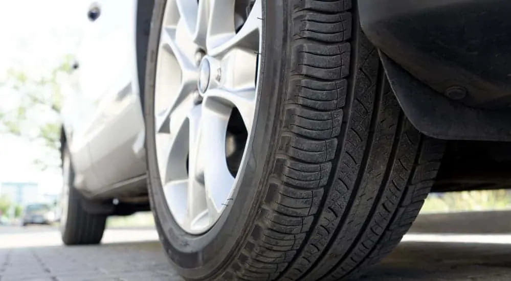 All-season tires are mounted on a silver car. 