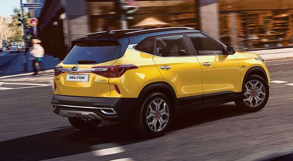 A yellow 2021 Kia Seltos, which is soon to be popular among Kia SUVs, is driving in the city.