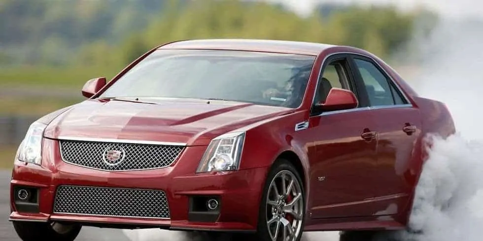 A red 2009 Cadillac CTS-V doing a burn out on a track