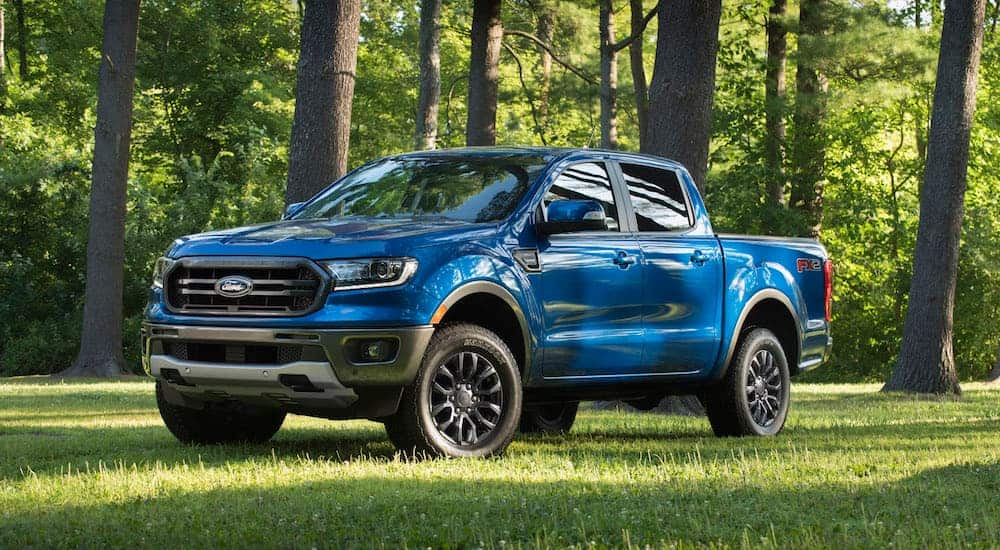 A blue 2019 Ford Ranger is parked on a shaded grassy area. 