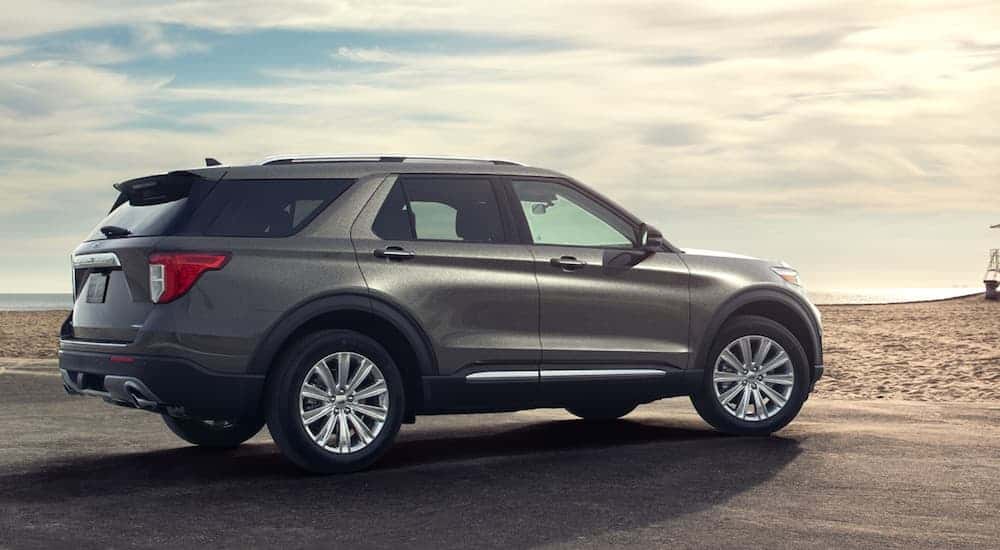 A grey 2020 Ford Explorer is parked on a beach while facing the ocean.