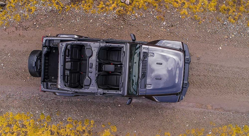 A birds eye view shows a topless 2020 Jeep Wrangler driving on a trail.