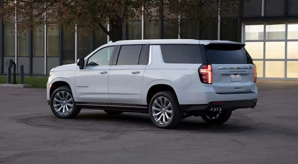 A white 2021 Chevy Suburban is shown in front of a building at dusk.