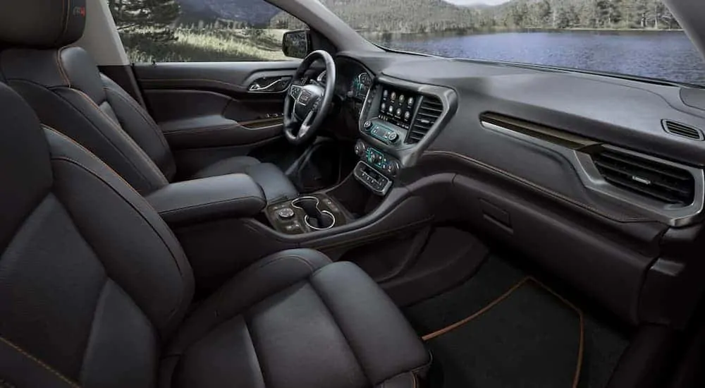 The front black leather interior of a 2020 GMC Acadia AT4 is shown with an infotainment system. 