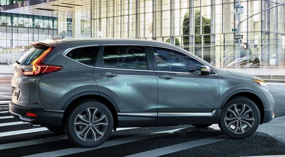 A silver 2020 Honda CR-V is driving through the city at night.