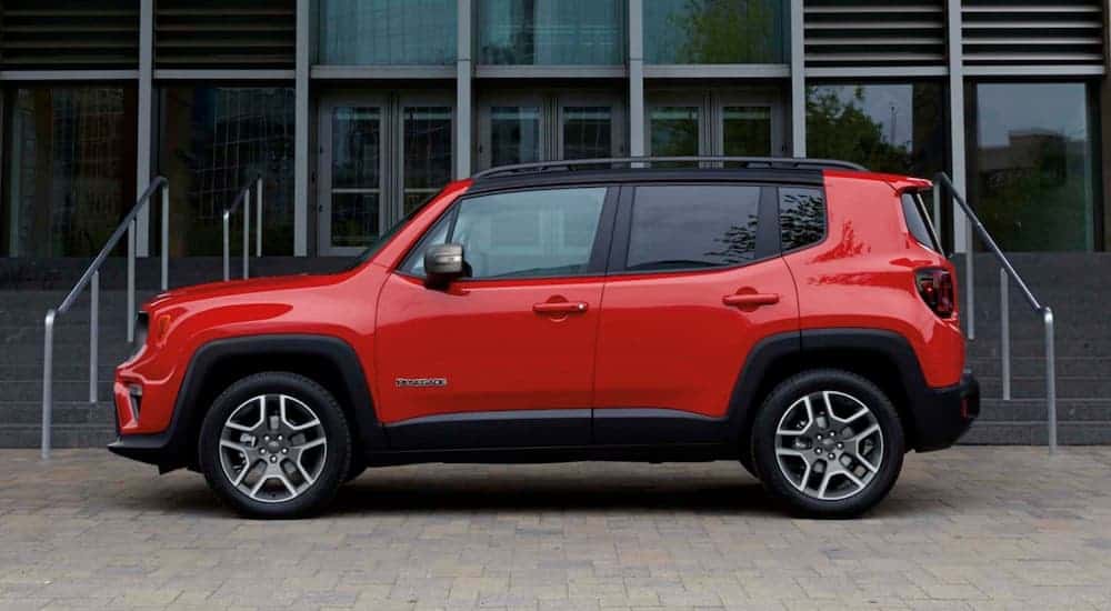 A red 2020 Jeep Renegade, which is popular among Jeep models, is parked in front of a building.