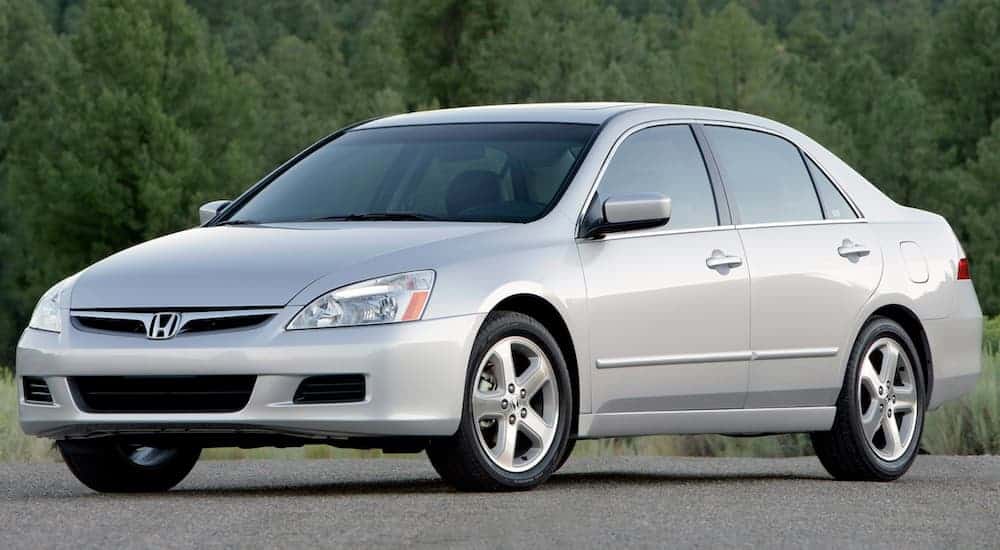 A silver 2007 Honda Accord is parked in front of trees.