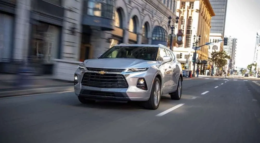 A silver 2020 Blazer is driving through a city.