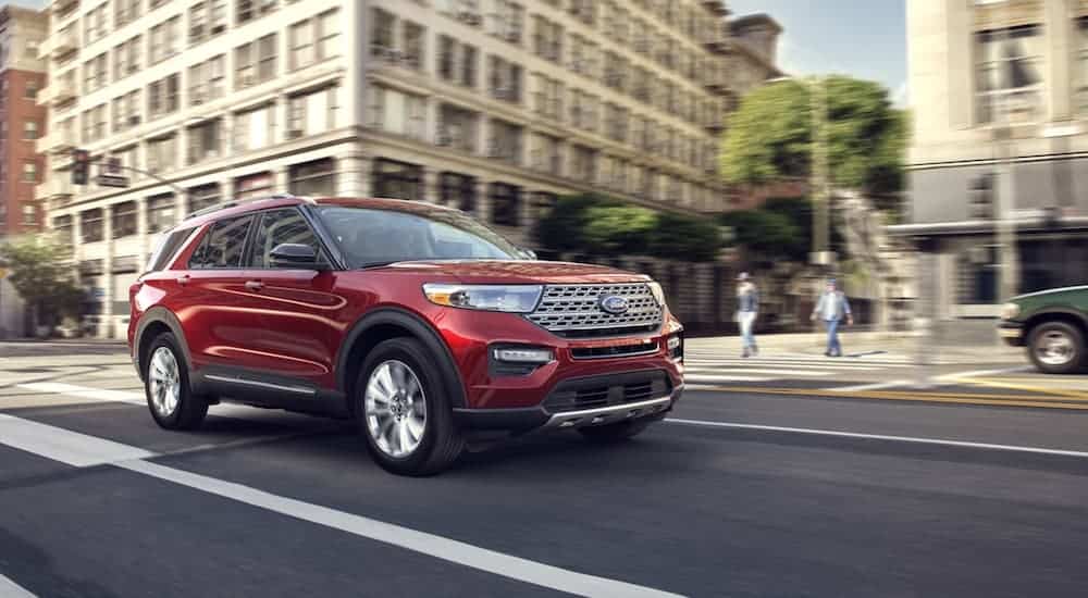 A red 2020 Ford Explorer is driving on a city street.