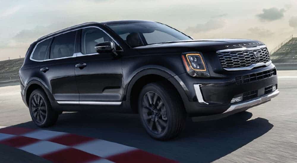 A black 2020 Kia Telluride is driving around a race track.