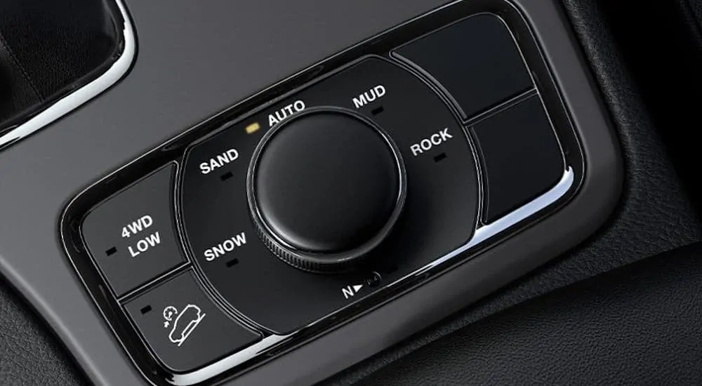 A closeup is shown of the traction control knob in a 2020 Jeep Grand Cherokee.