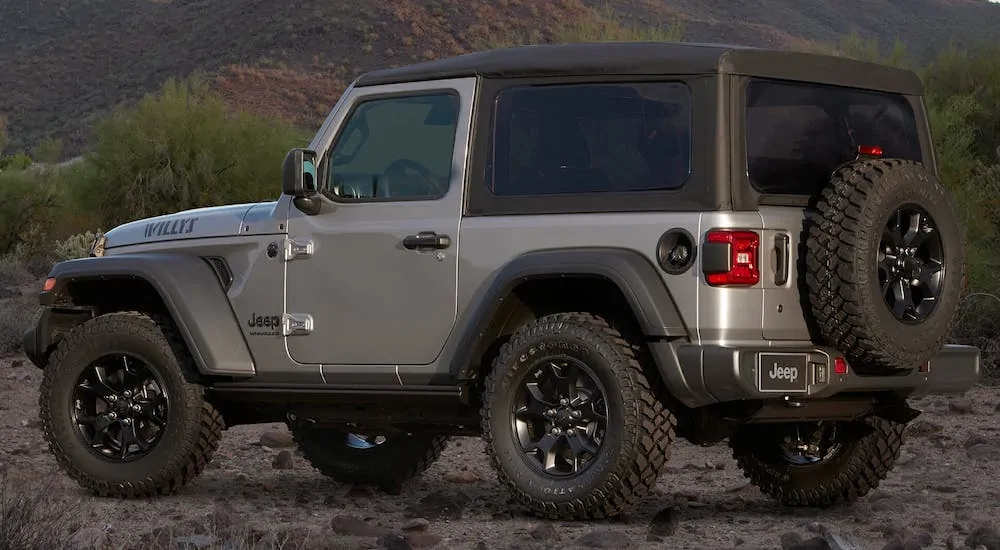 A silver 2020 Jeep Wrangler Willys edition is parked in front of a mountain.