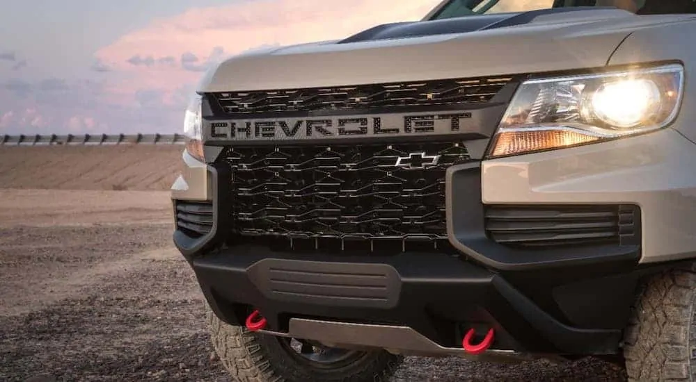 A closeup is shown of the grille on a tan 2021 Chevy Colorado ZR2 in a desert.