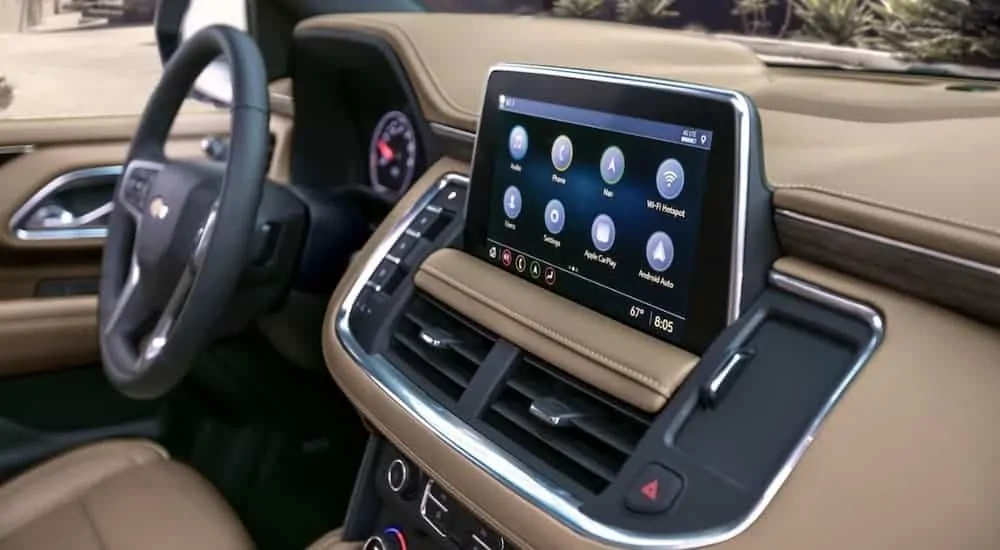 The infotainment display is shown on a tan dashboard on a 2021 Chevy Suburban.