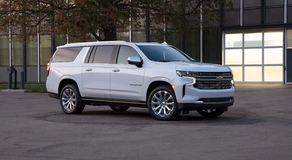 A white 2021 Chevy Suburban is parked in front of an office building.