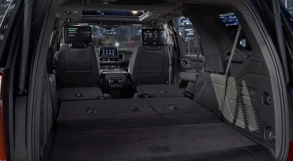 A look from the rear to the front of the black interior of a 2021 Chevy Tahoe is shown.