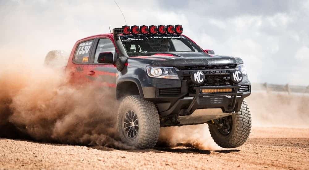A red racing edition 2021 Chevy Colorado ZR2 is kicking up sand in the desert.