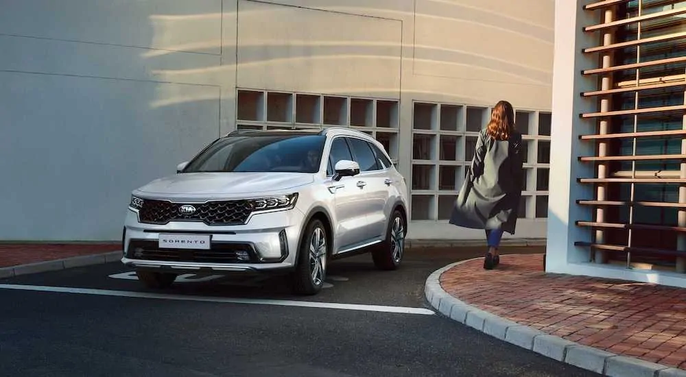 A white 2021 Kia Sorento is driving out of a parking garage.