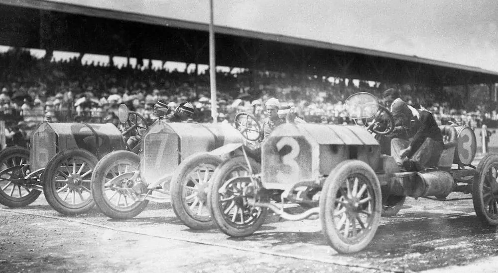 A black and white photo of a race at Indianapolis Motor Speedway in 1909 is shown.