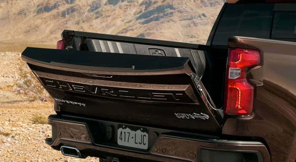 The hands free tailgate is shown lowering on a black 2020 Chevy Silverado.