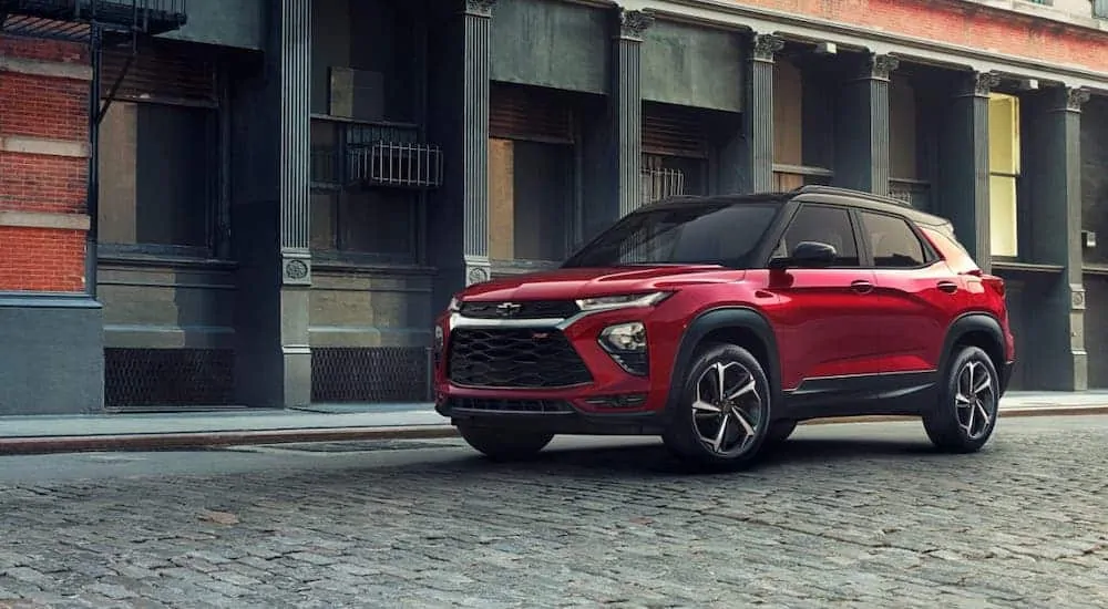 The winner of 2021 Chevy TrailBlazer vs 2020 Mazda CX-30, a red 2021 Chevy Trailblazer RS is parked on a cobblestone road.