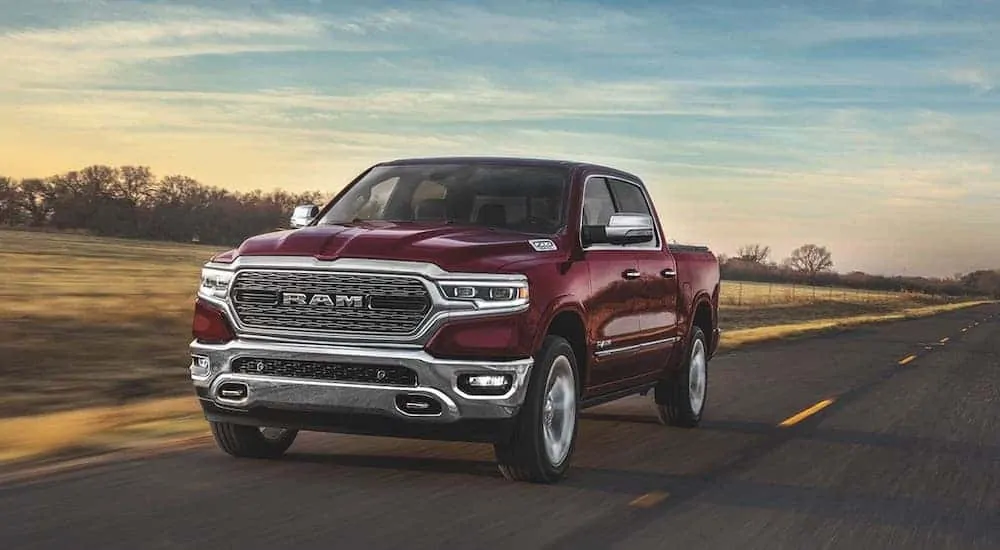 A red 2020 Ram 1500 Limited from a Ram dealership near you is driving on an isolated road